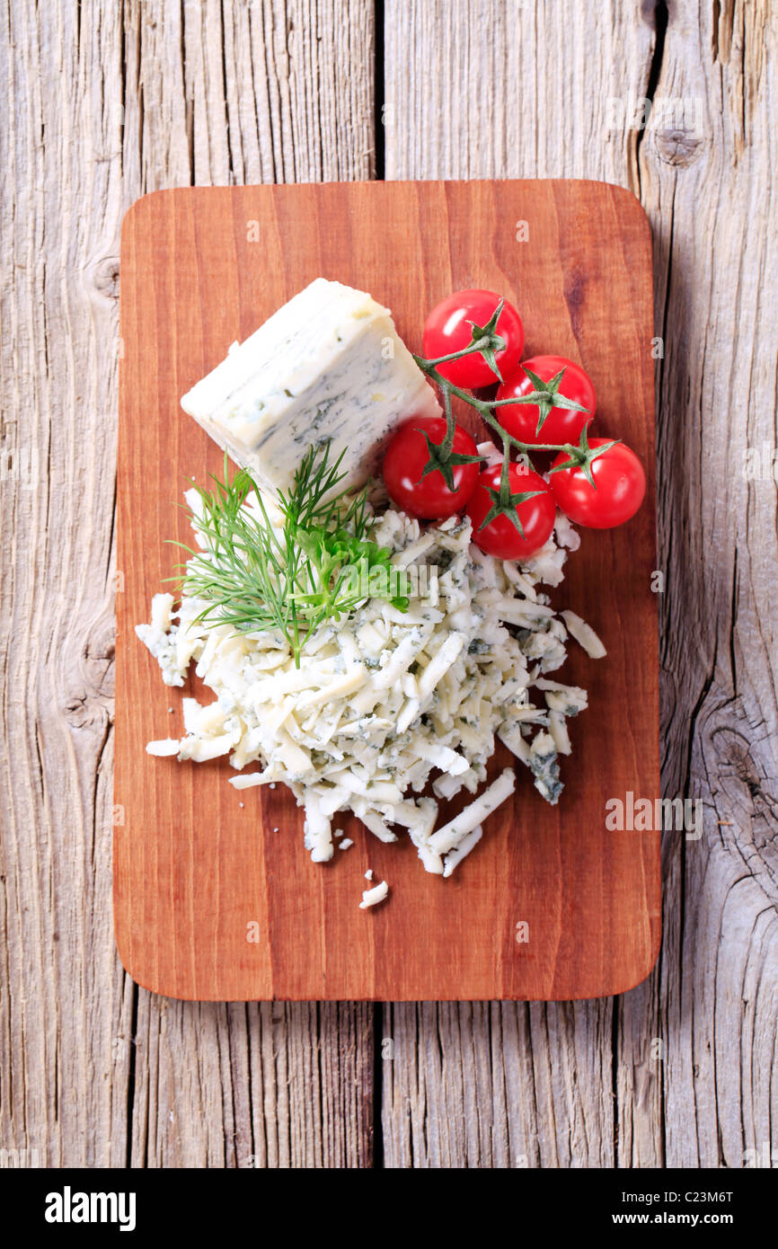 Formaggio blu e pomodori freschi su un tagliere Foto Stock