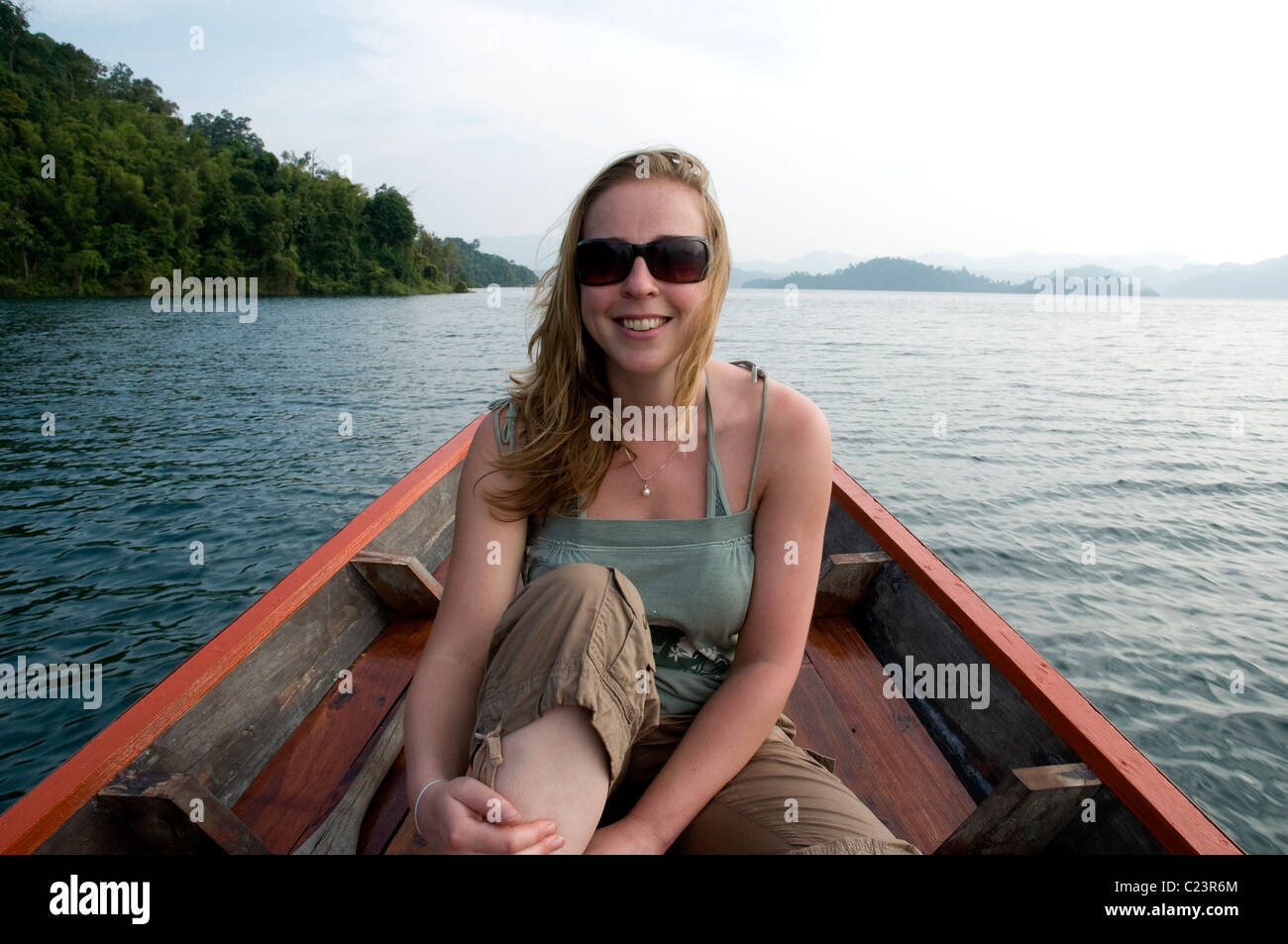 Turista femminile in un Thai Barca Long-Tail, Cheow Larn Lago, Khao Sok National Park, nel sud della Thailandia Foto Stock