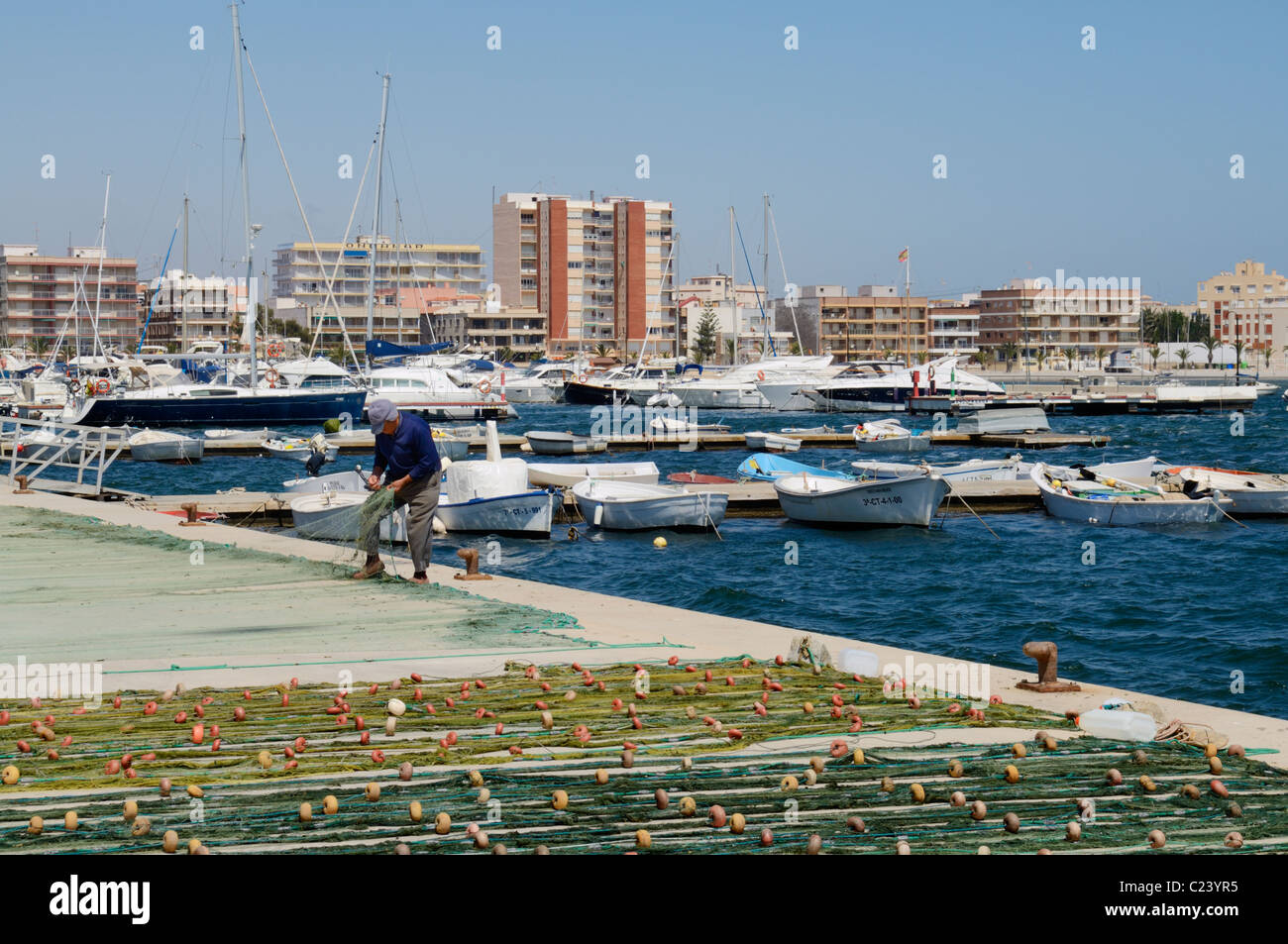 Un pescatore di tende per le sue reti sulla banchina del porto nel Mediterraneo Porto di San Pedro del Pinatar, Murcia, Spagna. Foto Stock