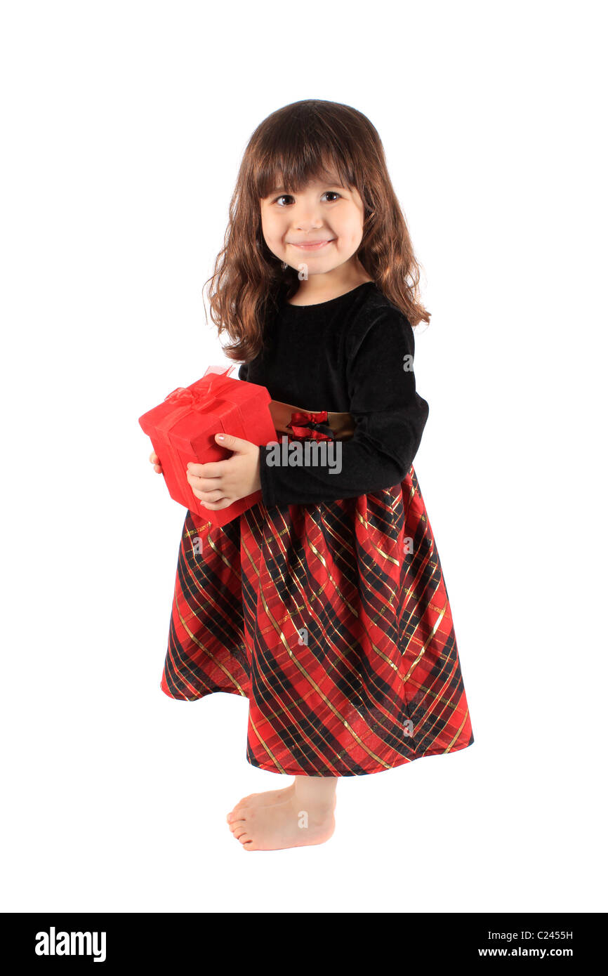 Carino tre anni di bambina vestito in un abito di fantasia tenendo un rosso giftbox a piedi nudi su sfondo bianco Foto Stock