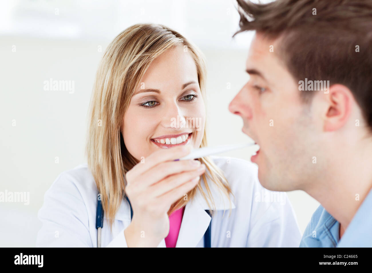 Ritratto di un medico donna prendendo un campione di saliva di un paziente di sesso maschile con cotone-bud Foto Stock