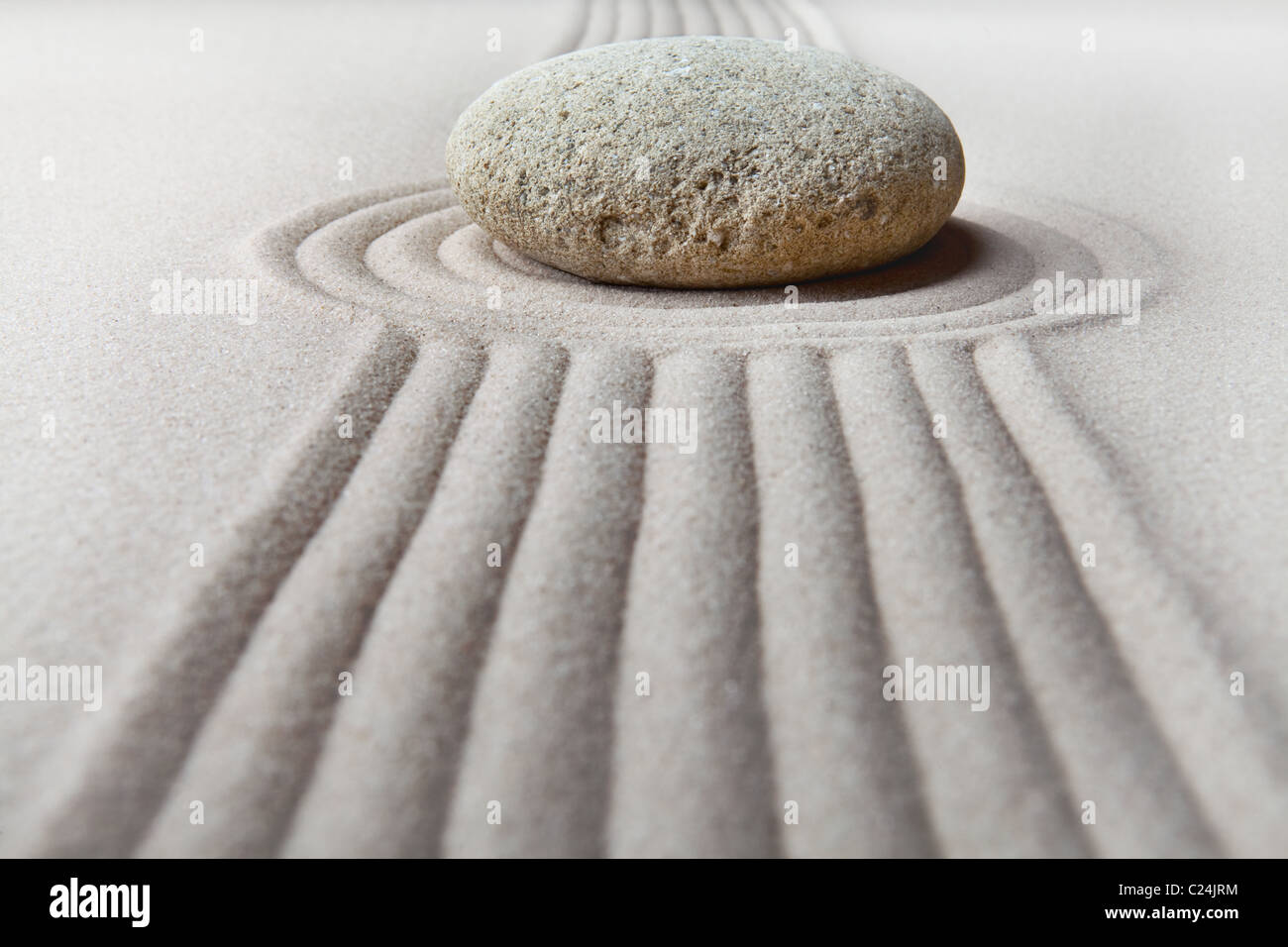 Giardino zen giardino giapponese zen stone con sabbia rastrellata e pietra rotonda tranquillità ed equilibrio increspature modello di sabbia Foto Stock