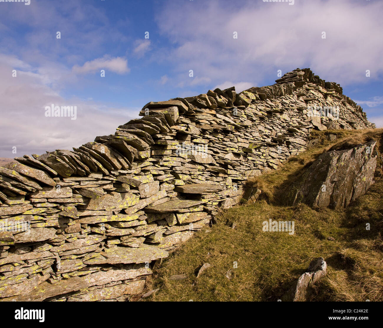 Il vecchio muro di pietra a secco in ardesia sul Lingmoor cadde contro il cielo blu, Lake District, Cumbria, Inghilterra, Regno Unito Foto Stock