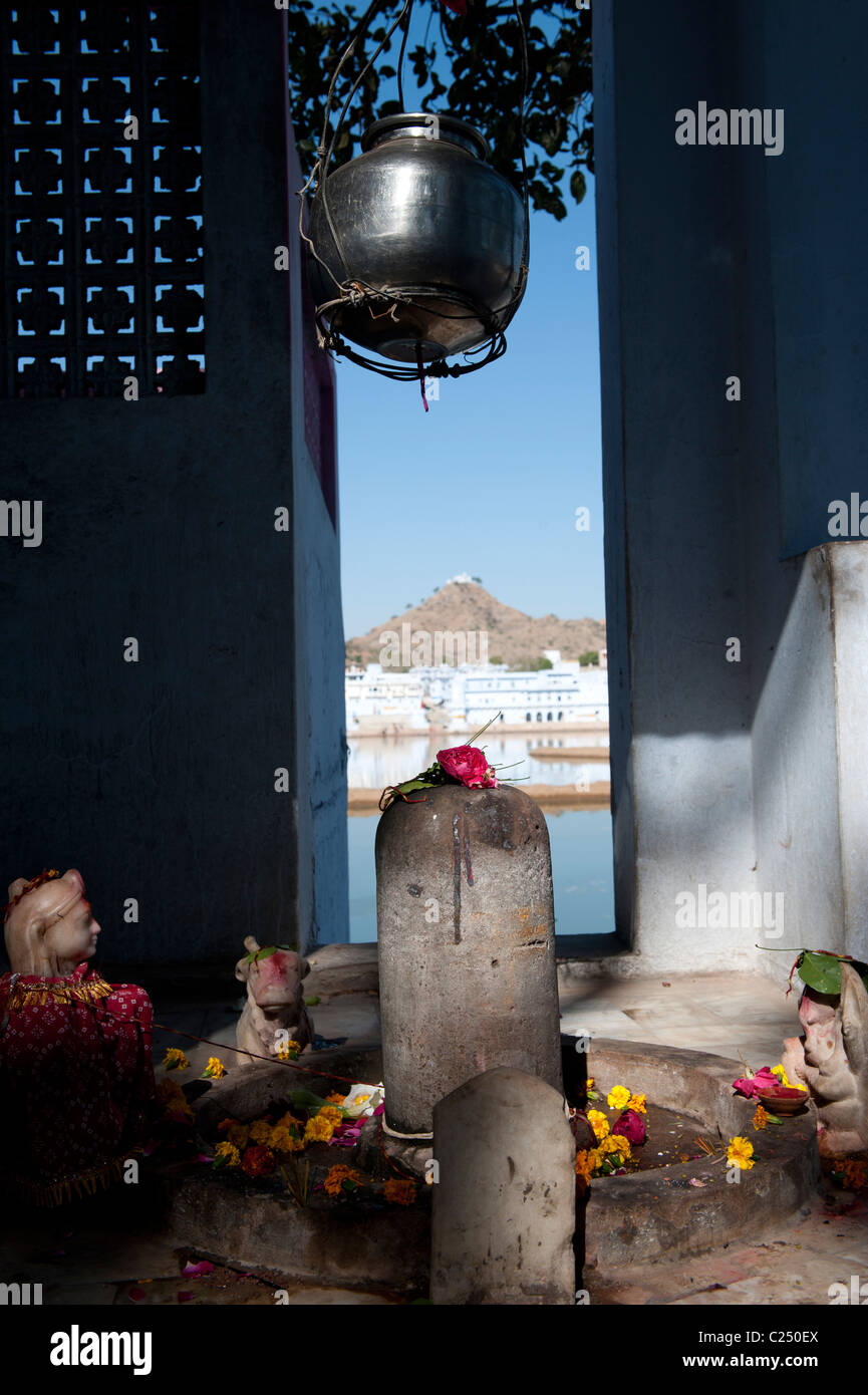 Un piccolo santuario in Pushkar' lakeshore con il Varaha tempio sulla cima della collina in background. Foto Stock