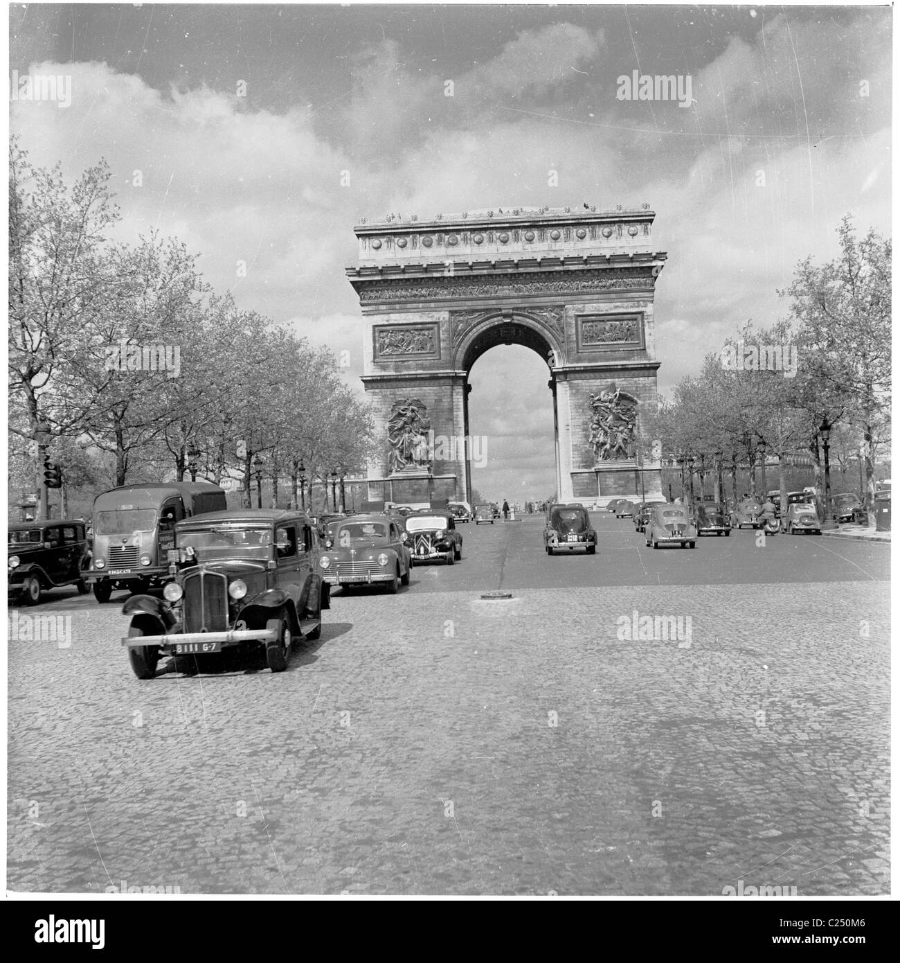 Francia,1950s. Le automobili e dal famoso punto di riferimento, l'Arc de Triomphe a Parigi. Foto Stock