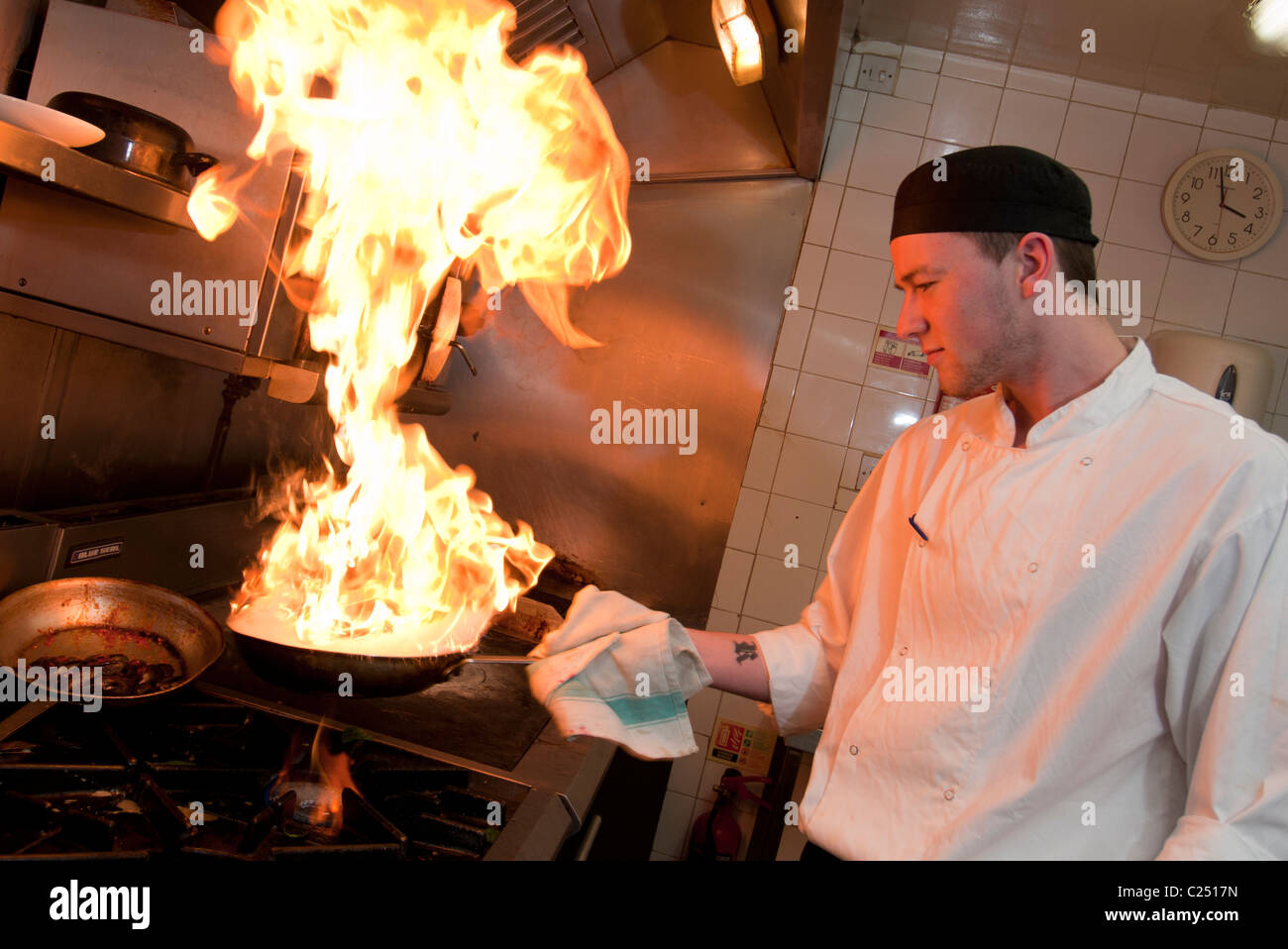La cucina dello chef in cucina con fiamme venuta fuori dalla padella , ristorante. Foto Stock