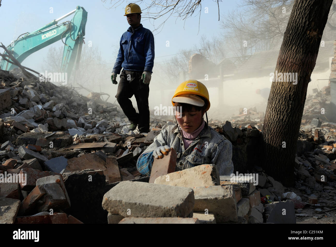 Donna cinese raccogliendo mattoni da ruderi di case diroccate nel centro di Pechino, Cina.20-Mar-2011 Foto Stock