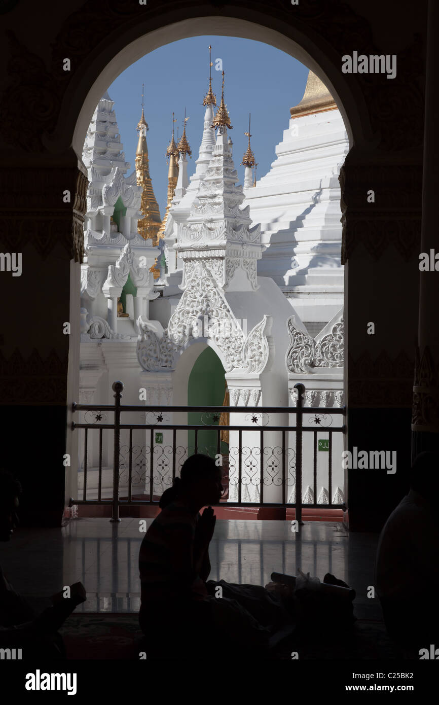 Interno del più grande tempio Buddista Shwedagon pagoda con donna orante, Rangoon, Birmania. Foto Stock