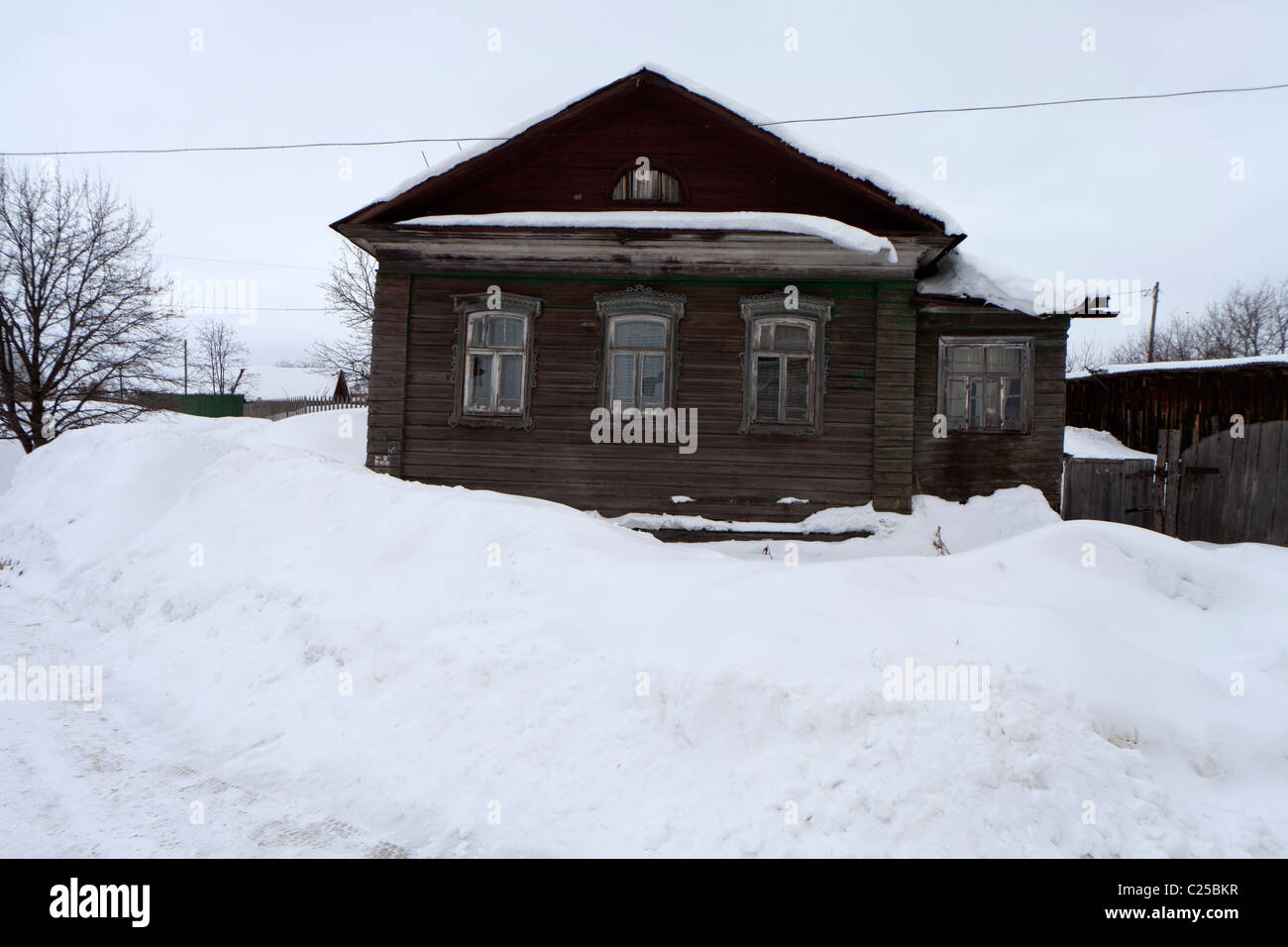 Vecchia casa in legno ricoperta di neve, dove più persone vivono nella città di Rostov, Russia Foto Stock