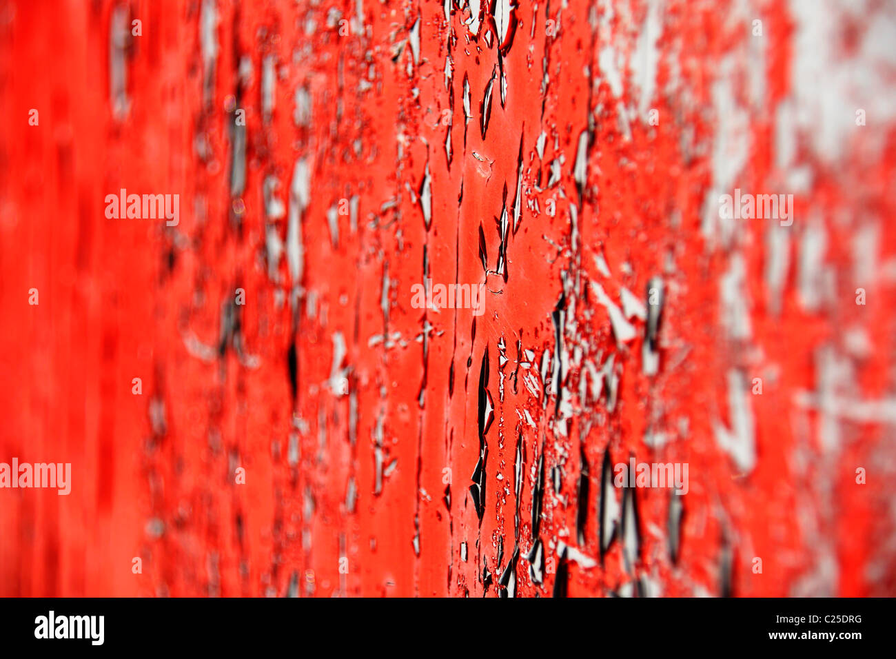 La pelatura di colore rosso brillante su vernice vecchia porta girato di un angolo per ottenere che molto poco profondo effetto DOF,messa a fuoco nel livello intermedio. Foto Stock