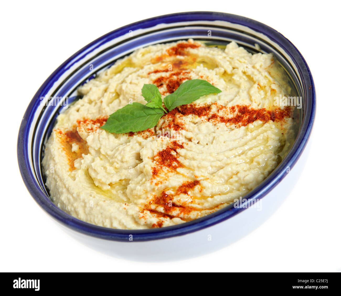 Hummus di ceci guarnita dip con la paprika e il basilico in un Tunisino-realizzata in ceramica ciotola con un tipico blu e bianchi. Foto Stock