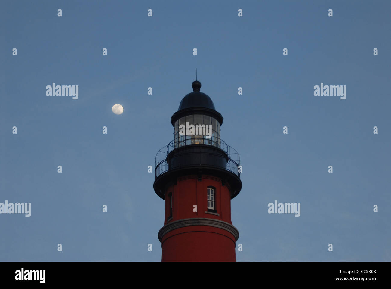 La luna sorge alle spalle di un faro a Ponce Inlet, Florida Foto Stock