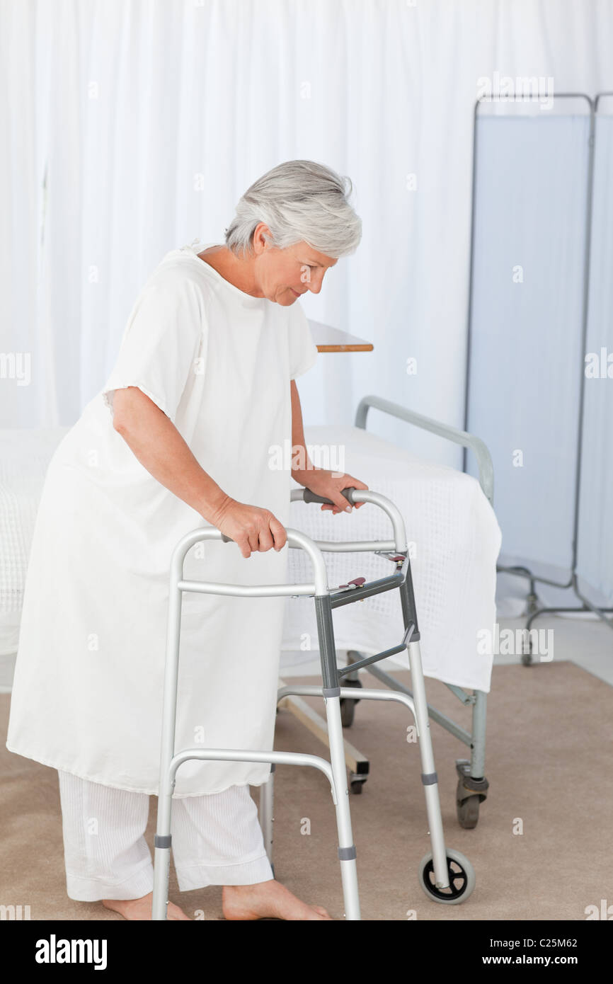 Senior donna con il suo telaio zimmer Foto Stock