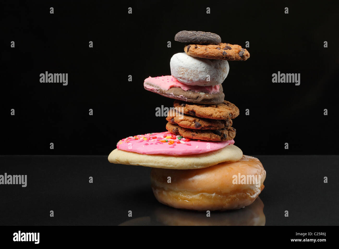 Pila di biscotti e dolci in Zen stack su sfondo nero Foto Stock
