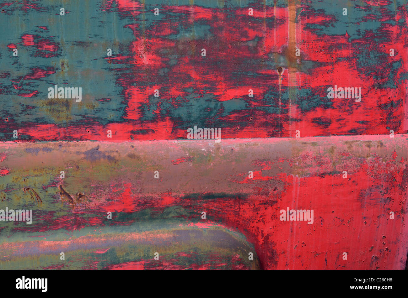 Abstract di blu e di rosso sfald vernice sul lato di un vecchio abbandonato arrugginimento carrello Foto Stock