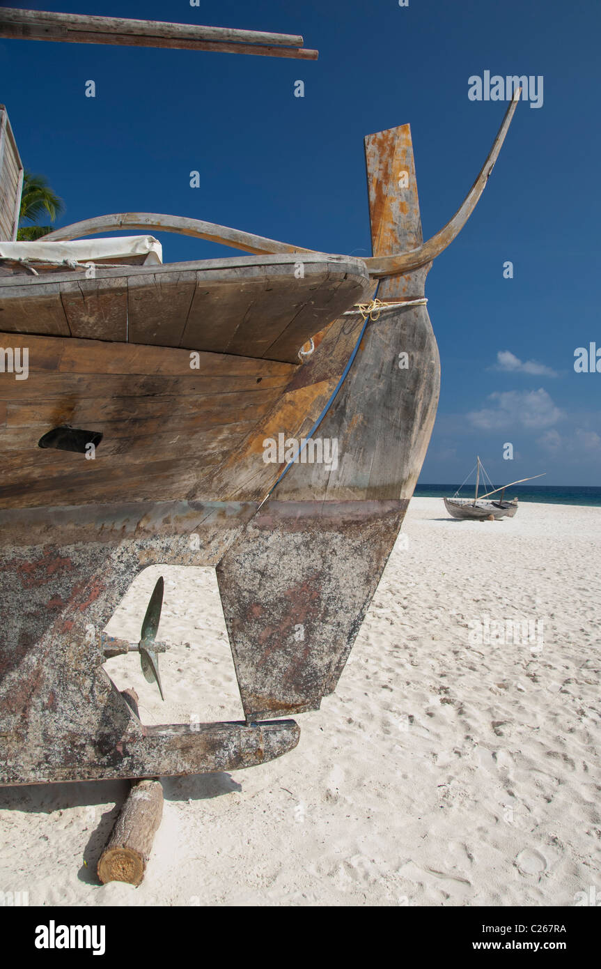 Maldive, North Male Atoll, Isola di Kuda Bandos. Vecchia barca sulla spiaggia, elica di poppa. Foto Stock