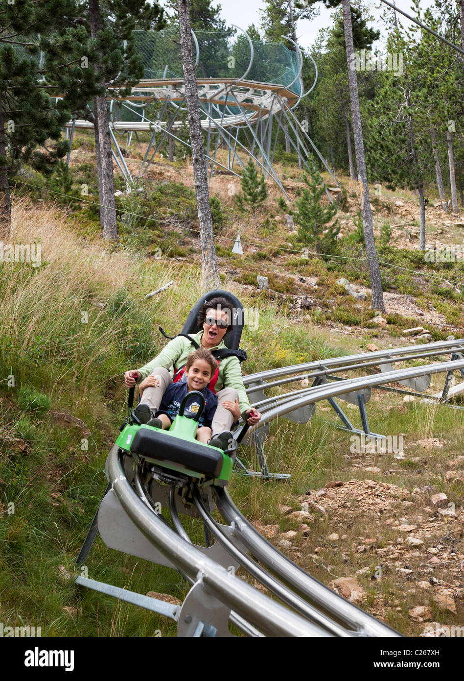 Donna e bambino sulla discesa in slittino Naturlandia eco-park parco avventura Tobotronc toboggan run Andorra Foto Stock