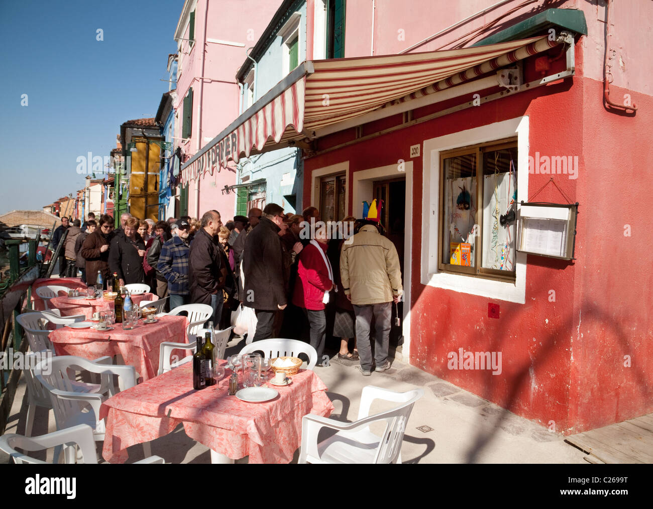 Una lunga coda per entrare in un ristorante nel villaggio di Burano Venezia Italia Foto Stock