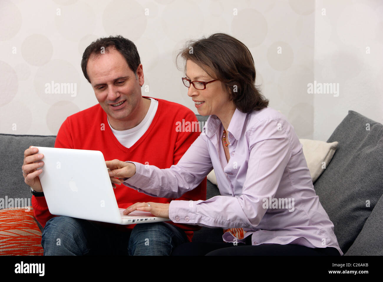 Giovane, uomo, donna siede a casa, lavorando con un computer portatile, la navigazione in Internet. Foto Stock
