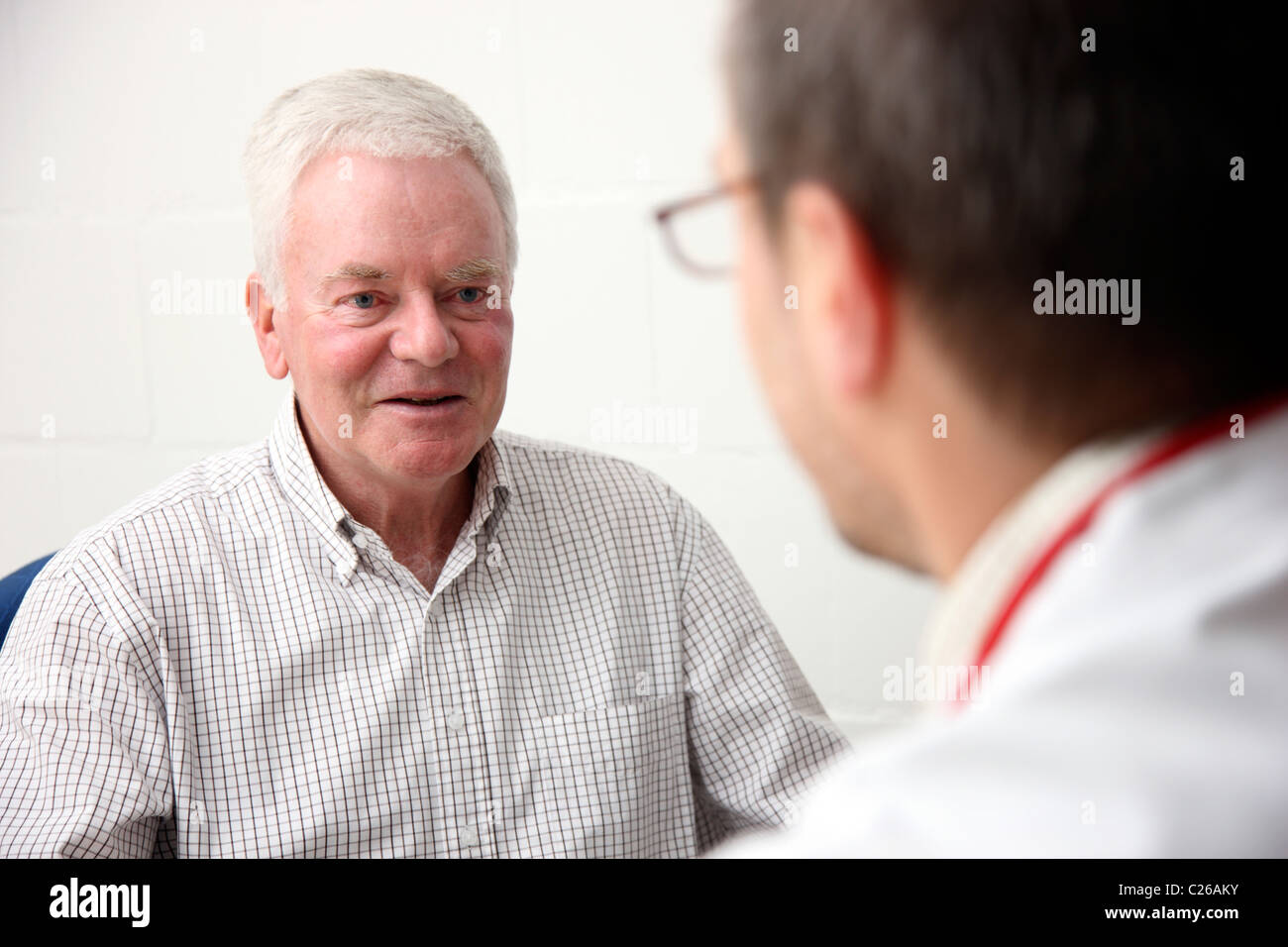 Senior, uomo, 71 anni, sesso maschile, in consultazione con il suo medico. Foto Stock