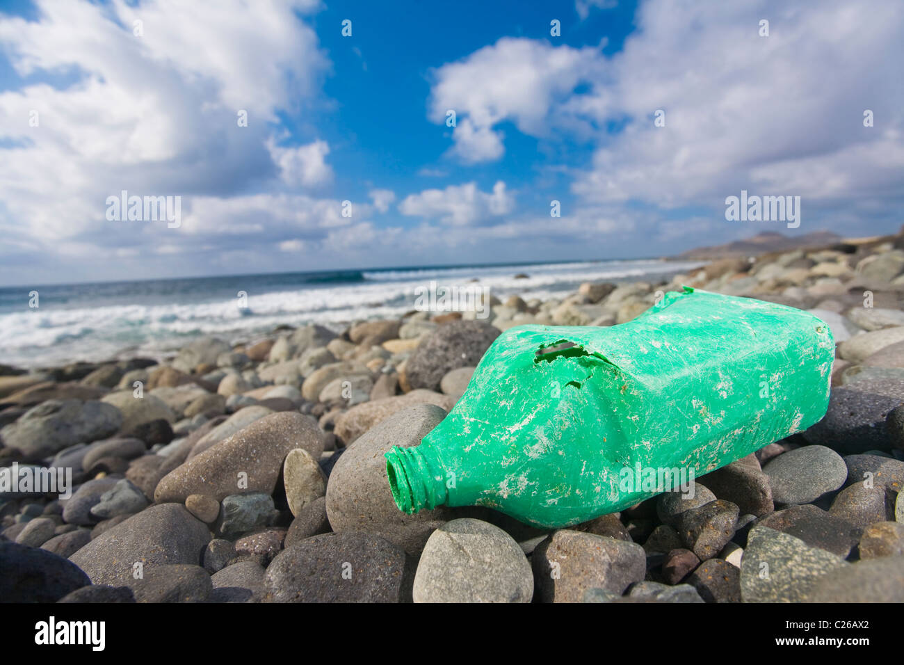 Una vecchia bottiglia di olio giacente su di una spiaggia rocciosa. Bel colpo per biodegradabili o ambiente concetti. Foto Stock