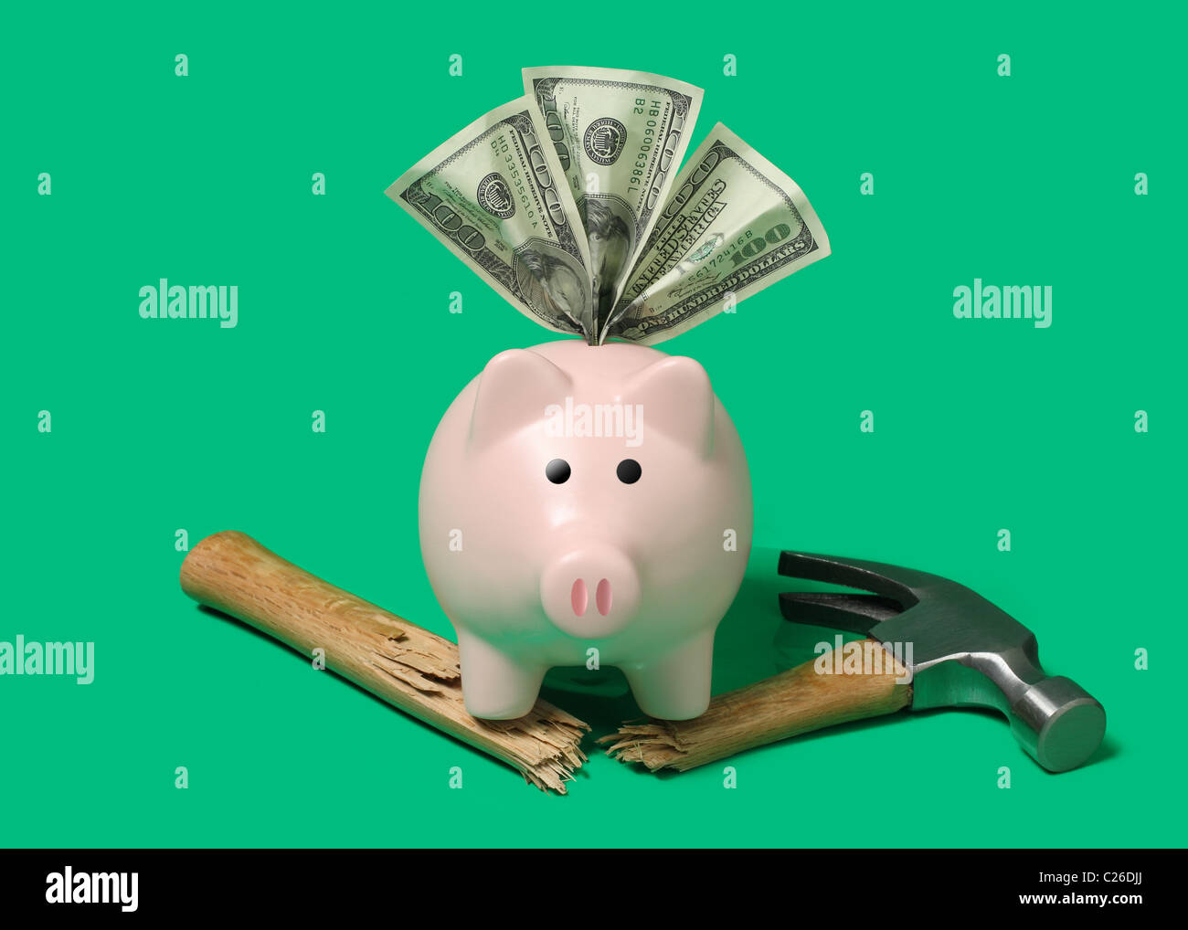 forte banca piggy con soldi e martello rotto taglio su sfondo verde Foto Stock