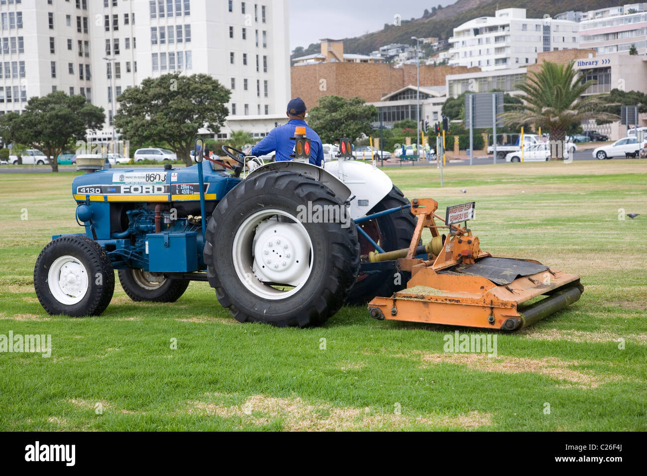 Uomo taglio erba sul punto mare lungomare di Città del Capo Foto Stock