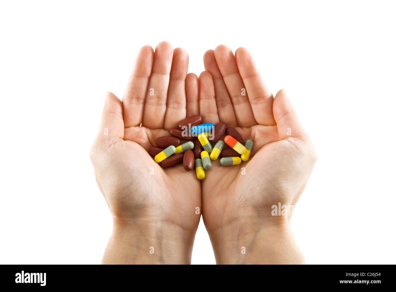 Mani aperte che offrono un assortimento di variopinte pillole e capsule Foto Stock
