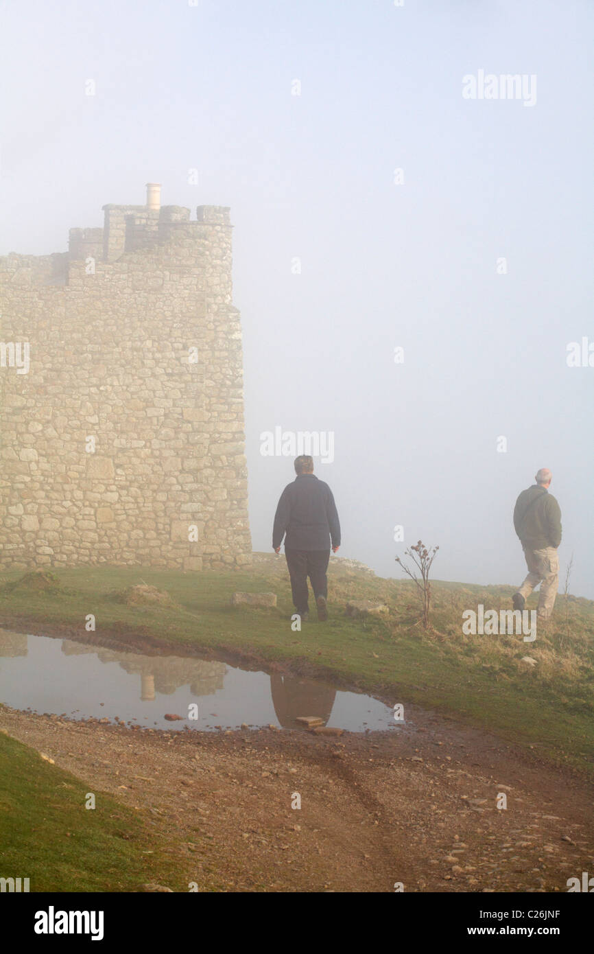 Coppia matura a piedi attorno al castello in caso di nebbia fitta su Lundy Island, Devon, Inghilterra Regno Unito nel mese di marzo Foto Stock