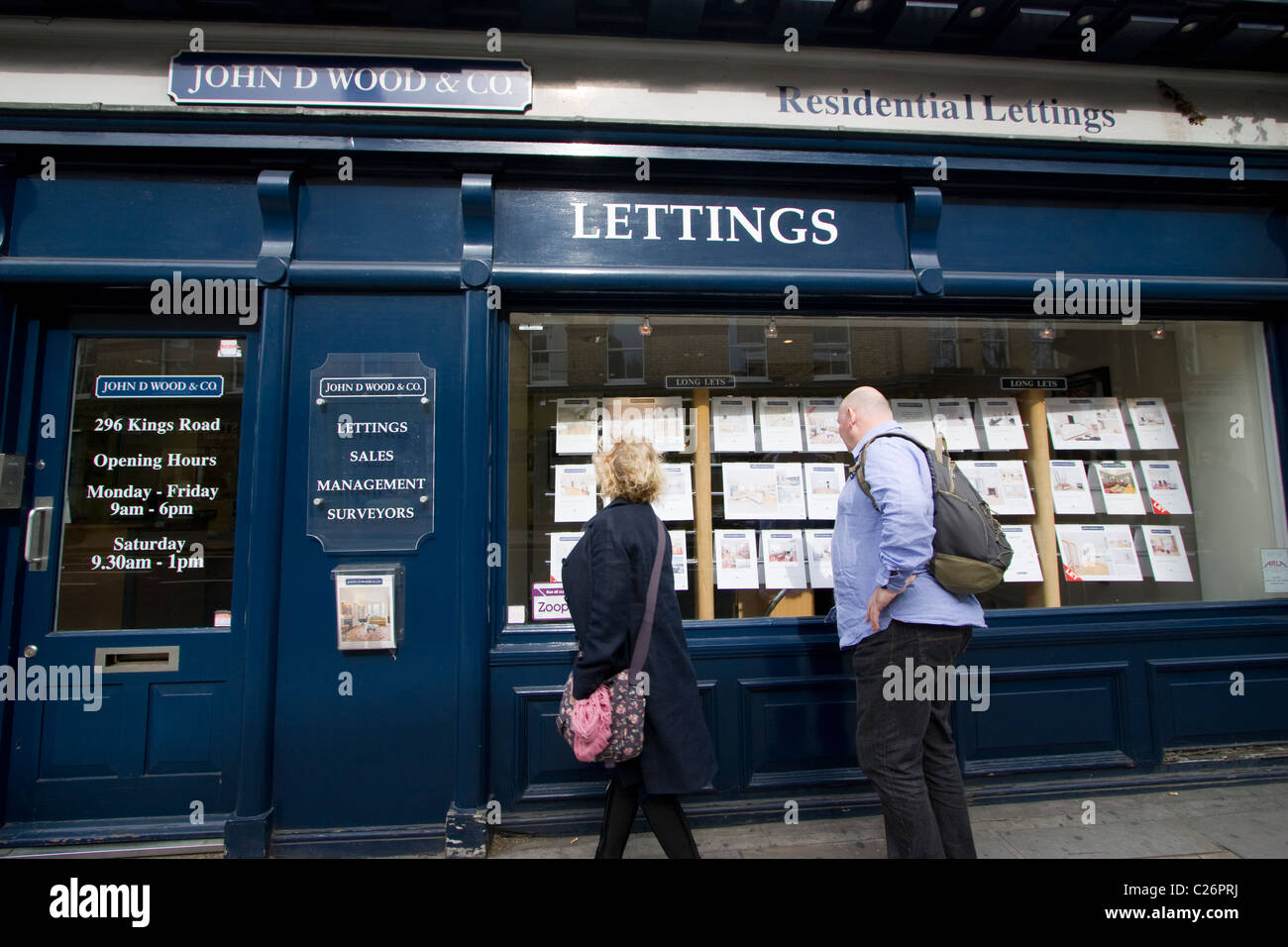Le persone che cercano nella finestra degli agenti immobiliari di John D Wood Londra Regno Unito Foto Stock