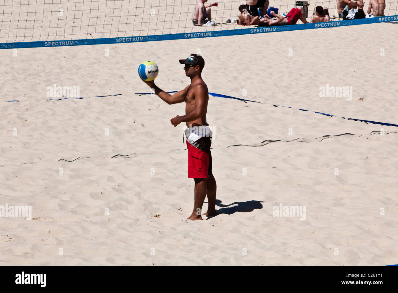 Un giocatore sempre pronto a servire in un beach volleyball match Foto Stock