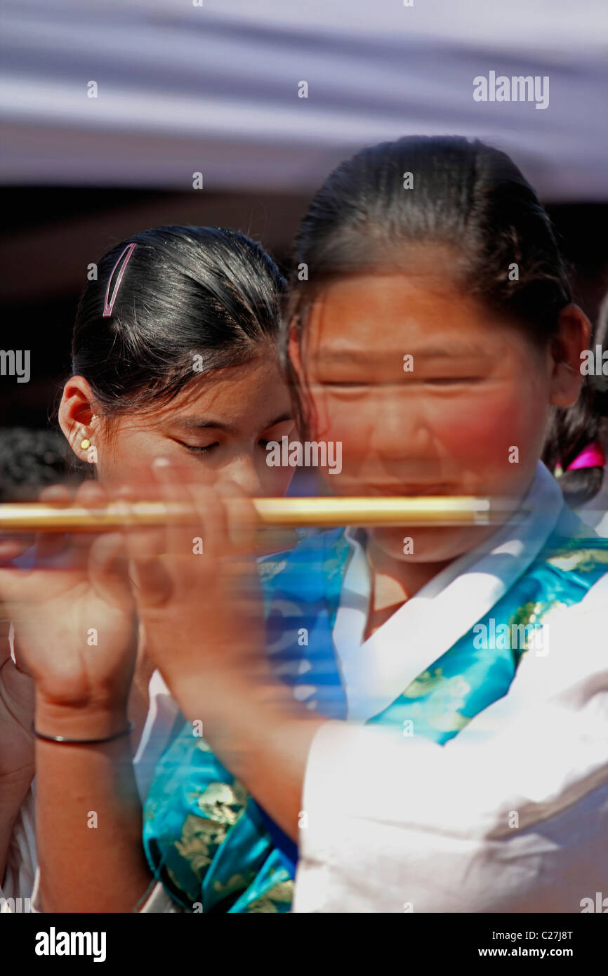 Una ragazza tibetana suonando i flauti a Namdapha Eco festival culturali, Miao, Arunachal Pradesh, India Foto Stock