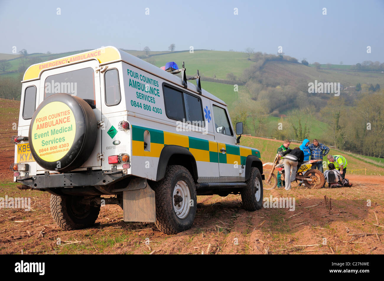 I paramedici evento che fornisce servizi medici frequentare un ciclista in corrispondenza di un evento di motocross. Il pilota ha camminato lontano sofferenza solo contusioni. Foto Stock