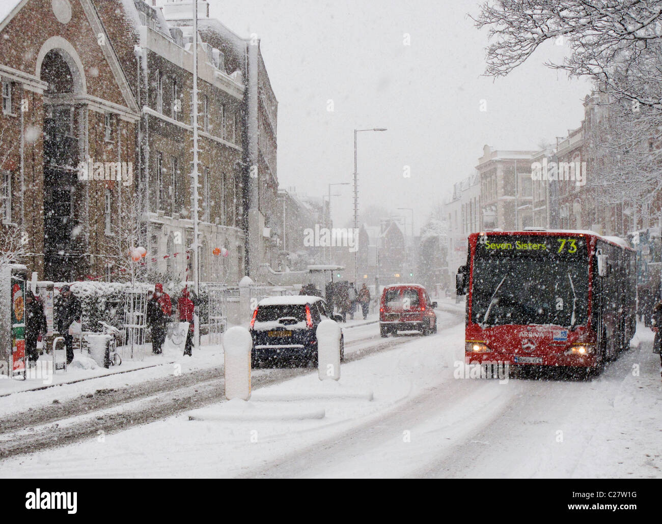 Bus e auto guidando attraverso la neve. Church Street, Stoke Newington, Londra. Foto Stock