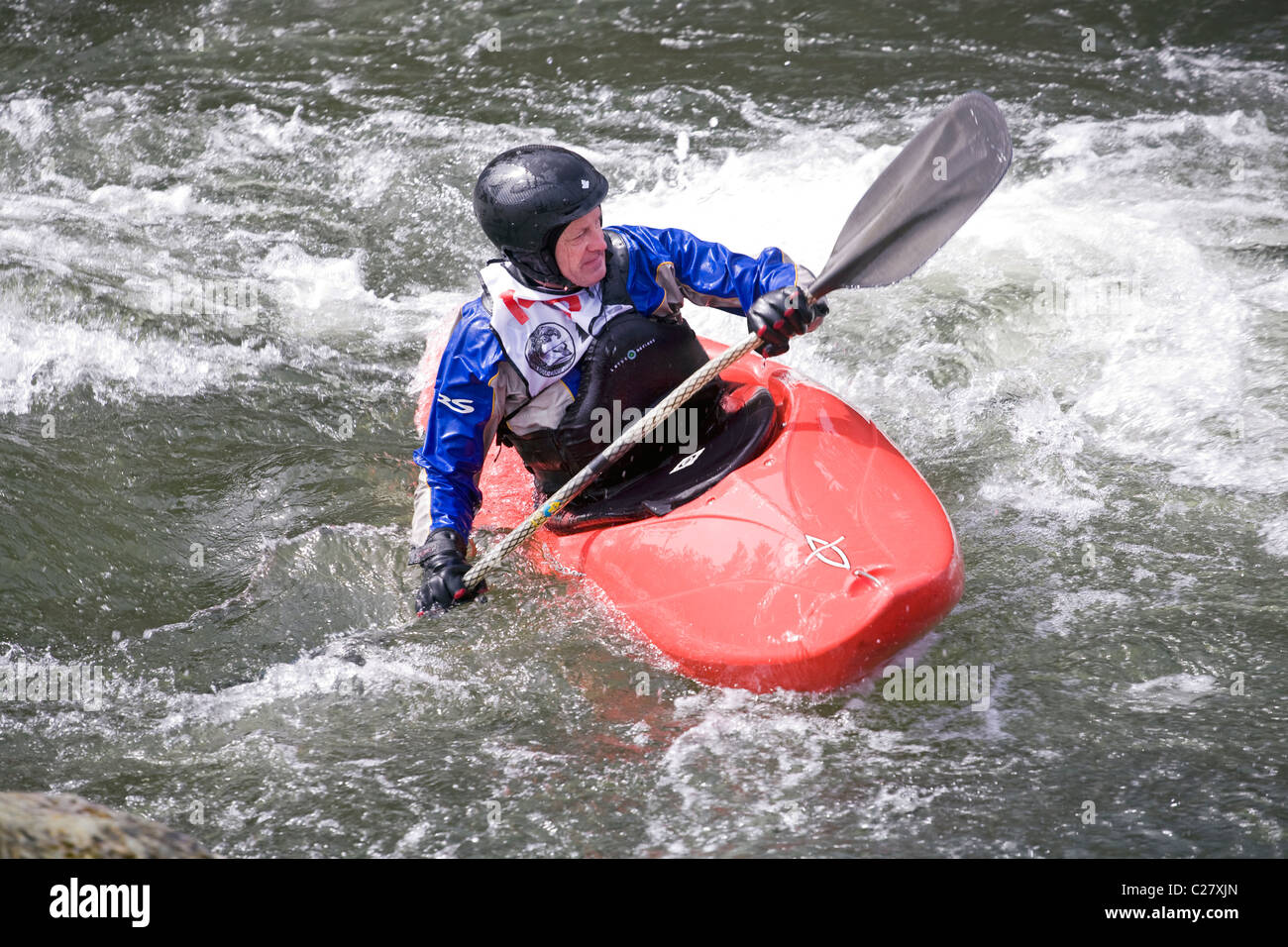 Un kayaker corre un difficile corso di kayak sul fiume Deschutes in curva, Oregon Foto Stock