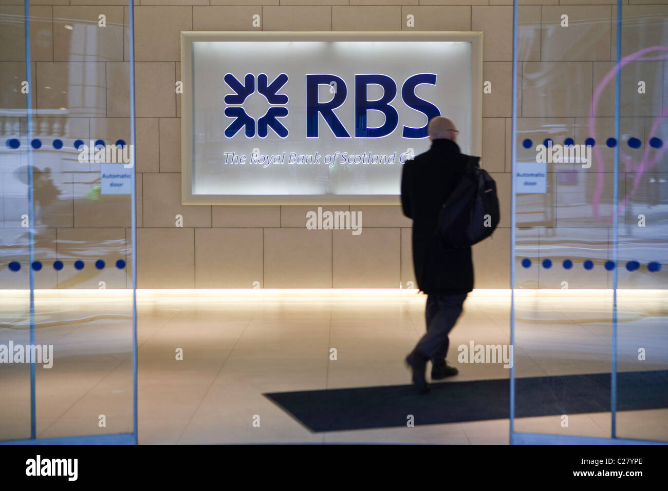 Un uomo arriva alla banca RBS sede della City di Londra. Foto Stock