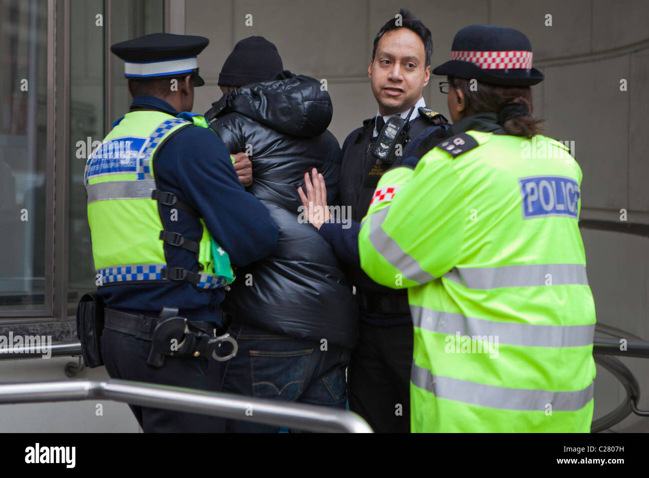 Un giovane maschio nero è arrestato su Ludgate Hill. Ci sono voluti dieci funzionari di polizia da varie forze per superare e arrestarlo. Foto Stock