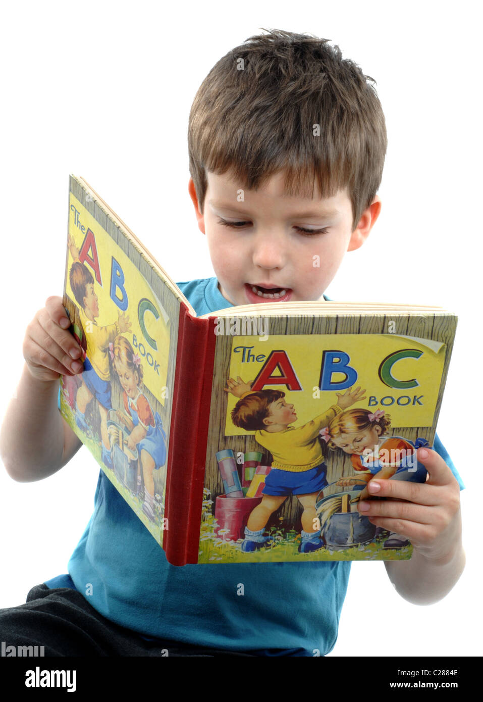 Ragazzo leggendo un libro e lettura per bambini Foto Stock