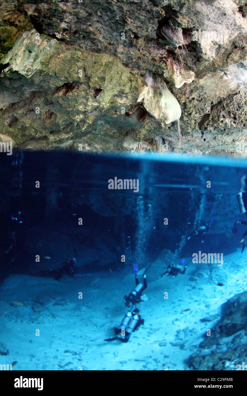 La fotocamera si trova esattamente a metà strada underwater mostrando i subacquei e la grotta sono circa da esplorare. Foto Stock