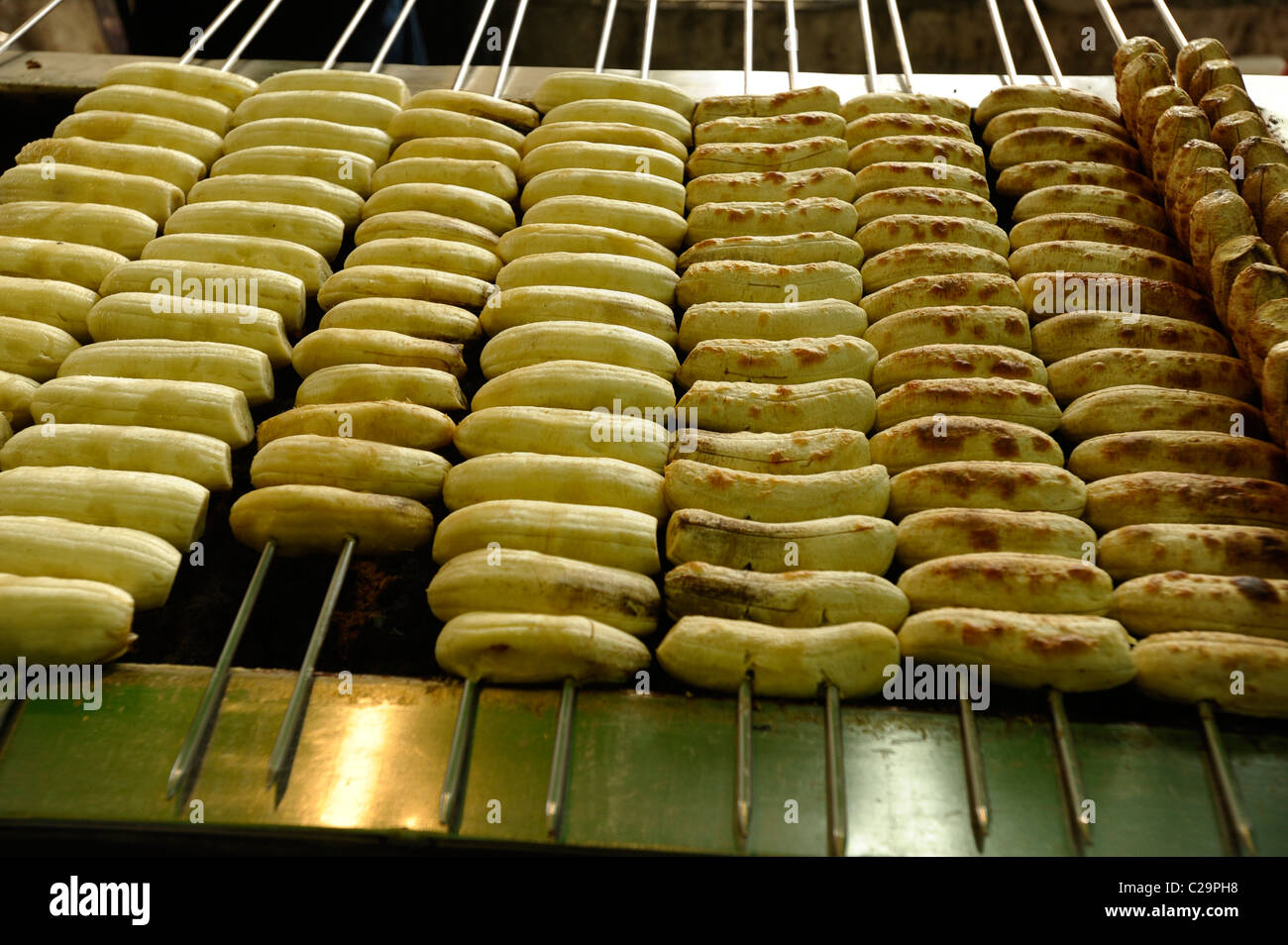 Banana bbq sul bastone, tailandese snack dolce, il mercato notturno , bangkok, Thailandia Foto Stock