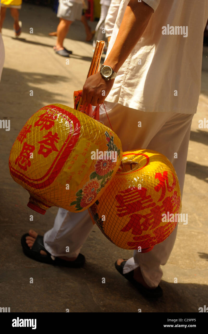 Thai uomo cinese portando lanterne cerimoniale durante il festival vegetariano ,wat cantato heng yee, Chinatown, Bangkok, Thailandia Foto Stock