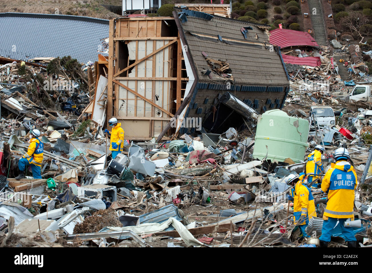 La ricerca in giapponese e delle squadre di soccorso alla ricerca di superstiti dopo migliaia di abitazioni sono state distrutte dopo un 9.0 Mw terremoto Foto Stock