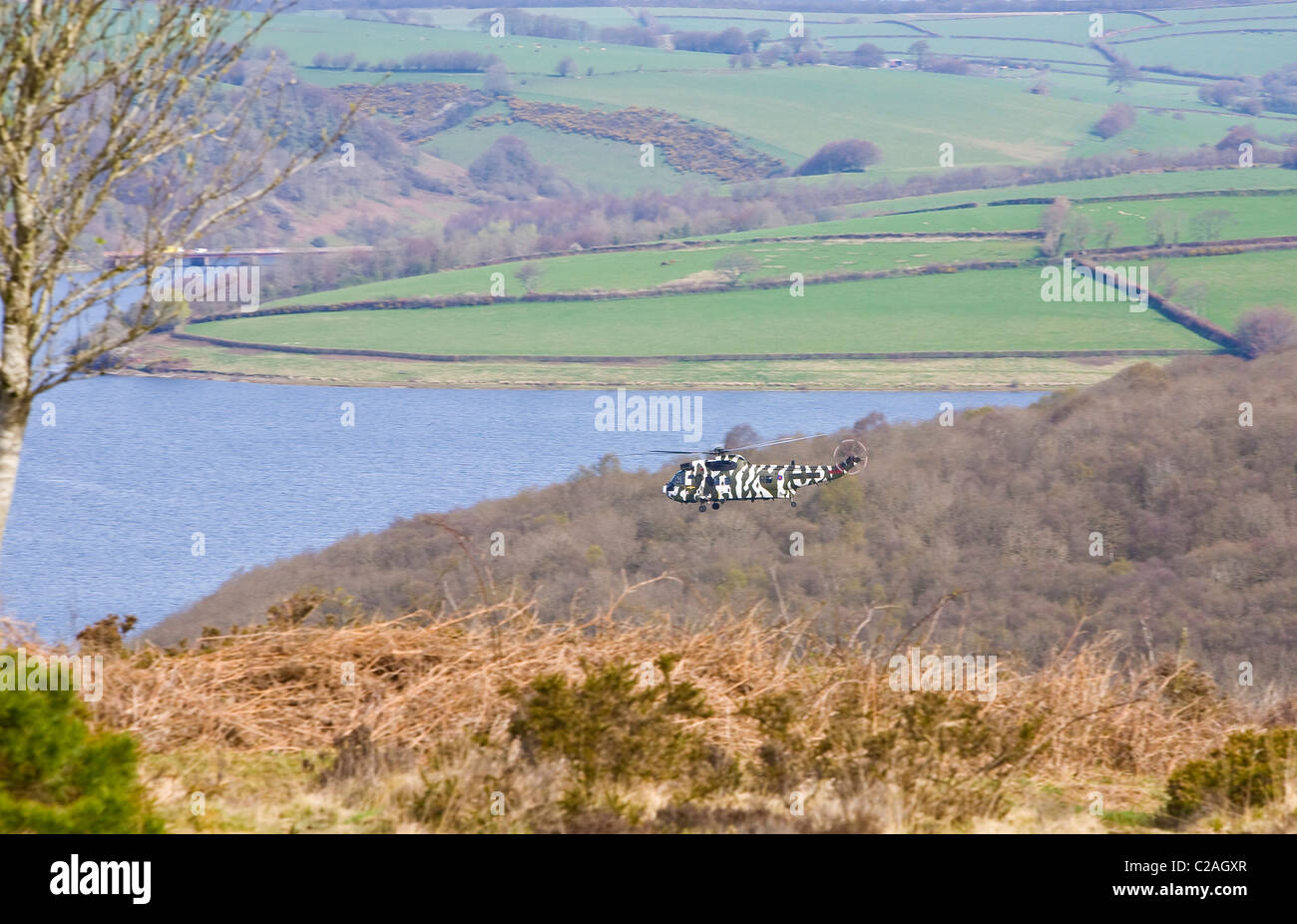 Una Marina Sea King elicottero volando sul lago Wimbleball Parco Nazionale di Exmoor Somerset Foto Stock