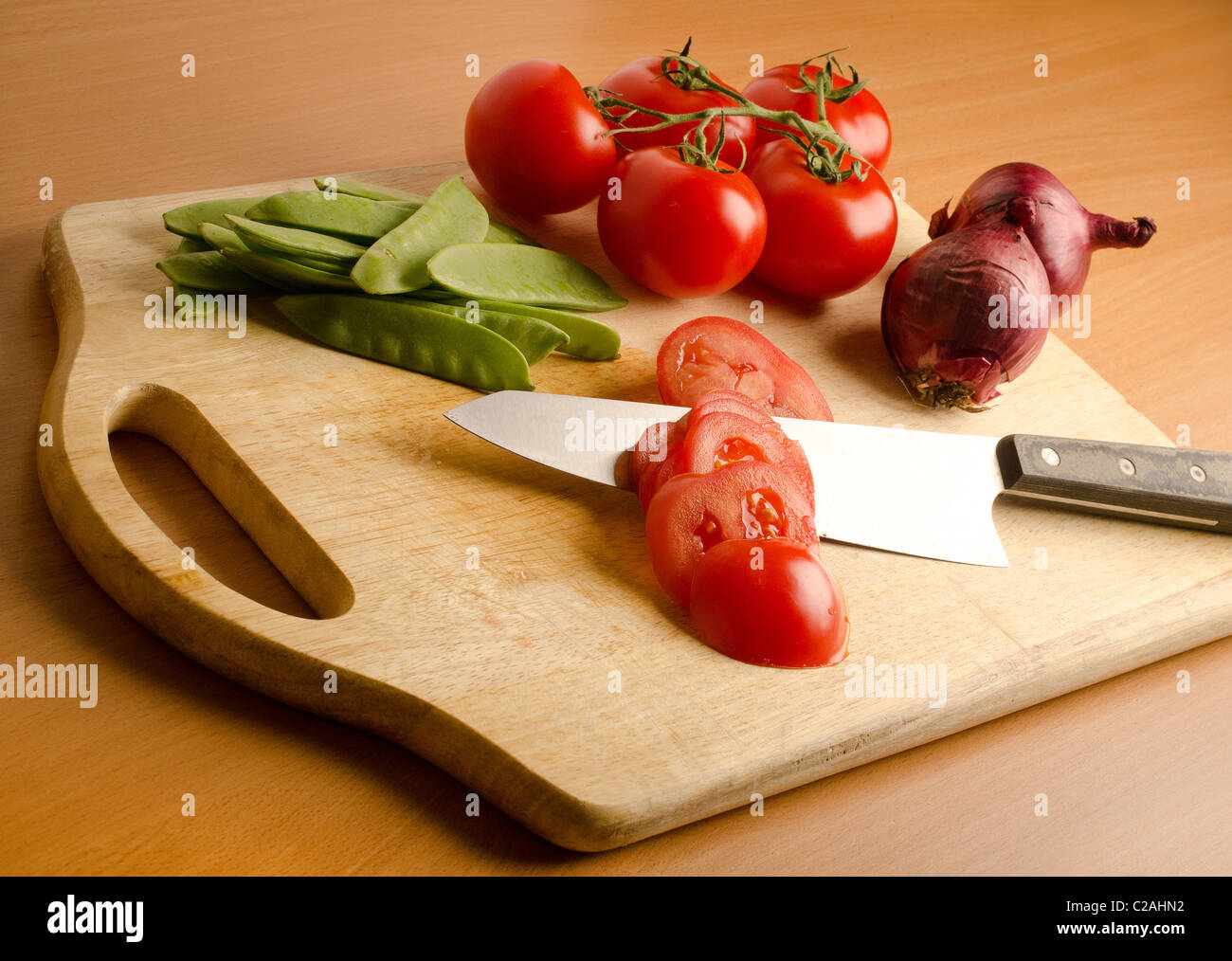 Un mazzetto di verdure fresche su un tagliere di legno Foto Stock