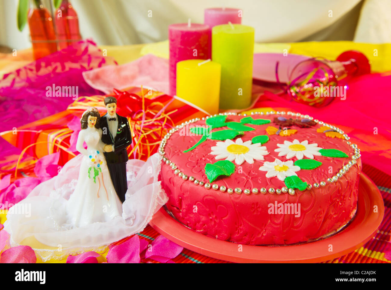 Coppie in viaggio di nozze nella parte anteriore di una torta in rosa ancora vita Foto Stock