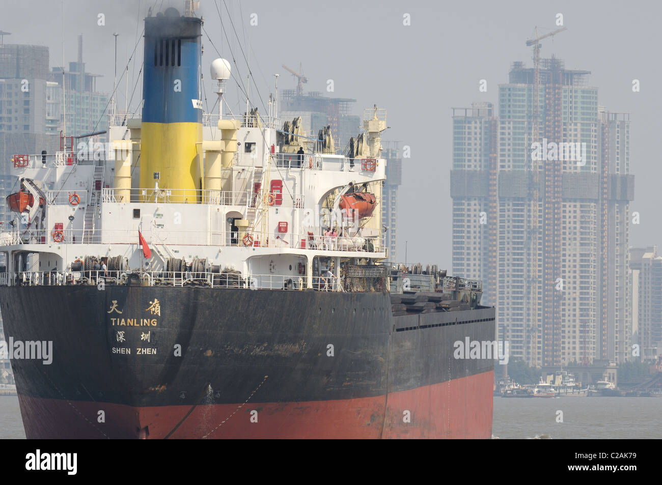 Il porto di Shanghai con una grande nave da carico. Gli edifici in background. Teleobiettivo shot. Foto Stock