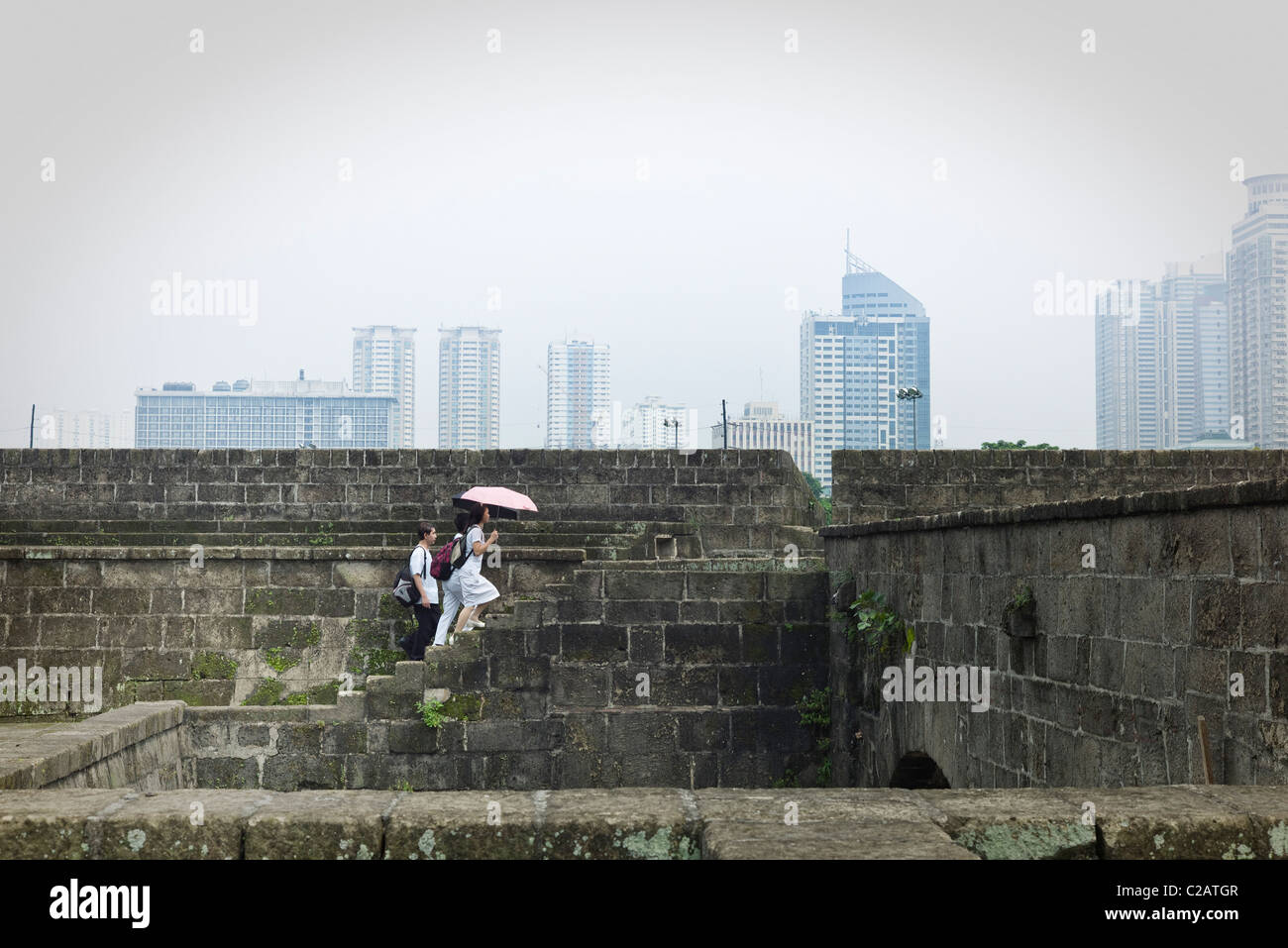 Filippine, Luzon, Manila, i pedoni a camminare su gradini dello skyline della città in background Foto Stock