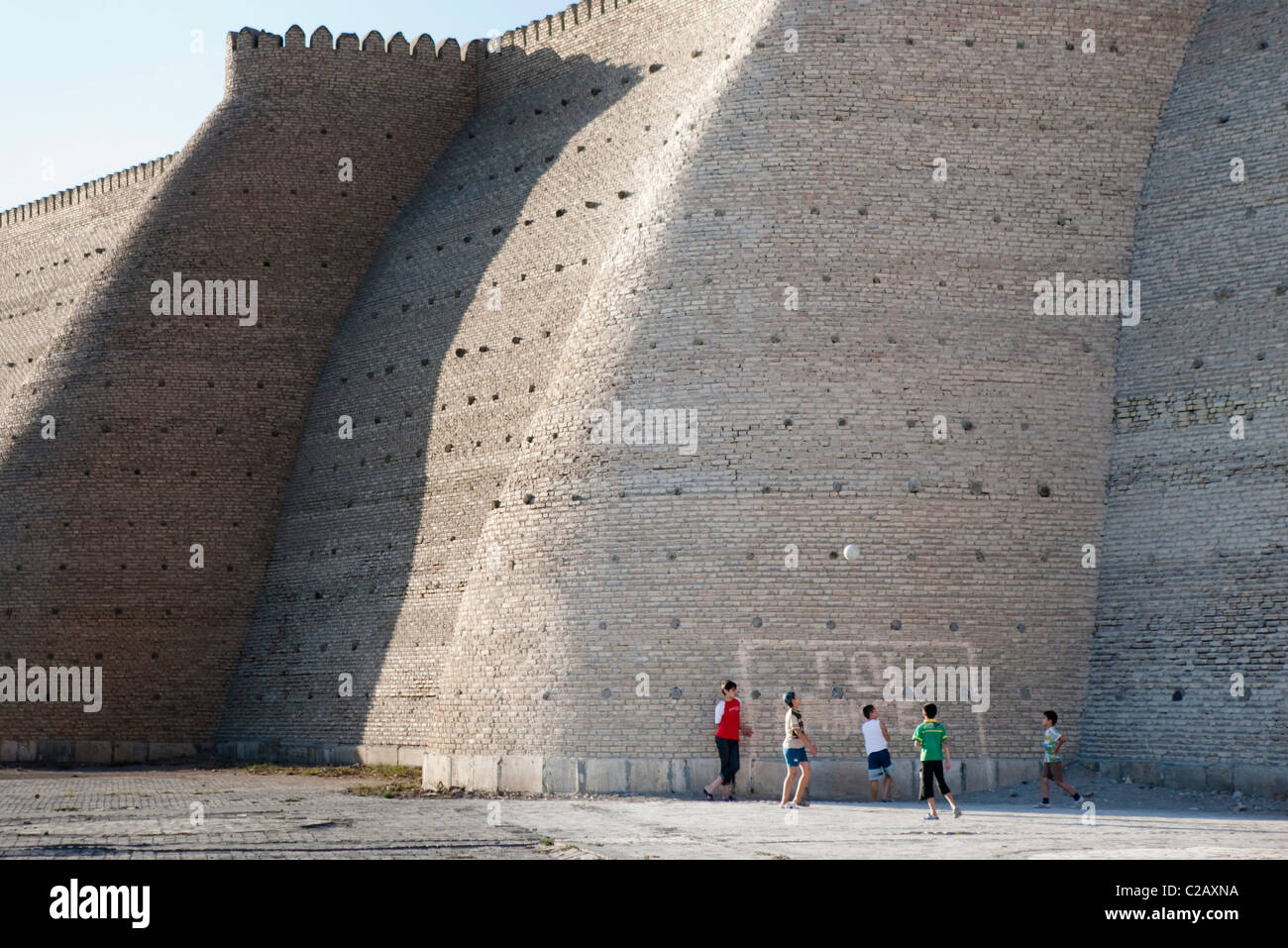 Uzbekistan Bukhara, bambini giocare a palla dall'Arca (fortezza) di Bukhara Foto Stock