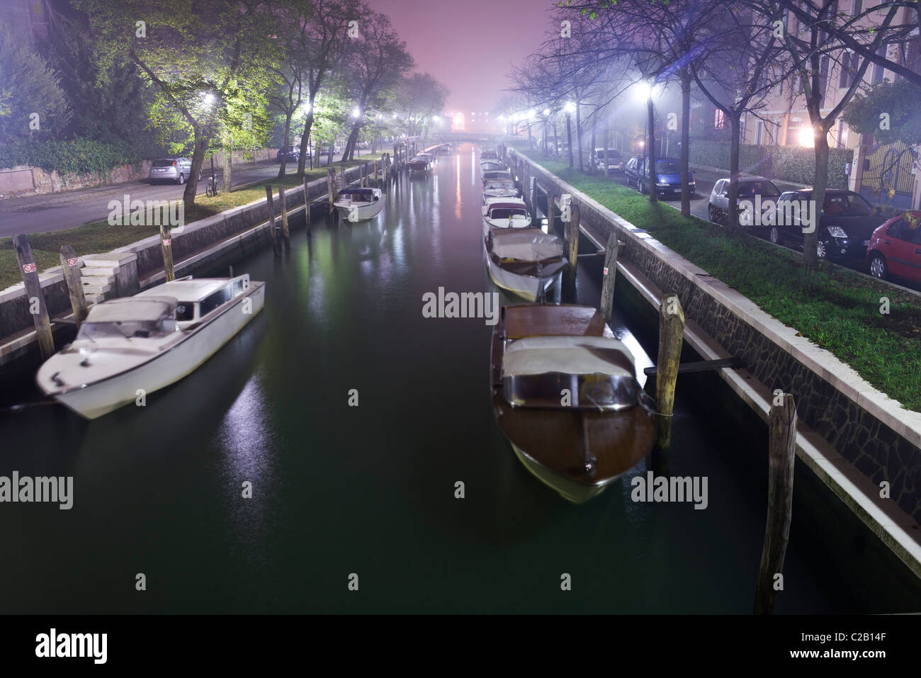 Barche ormeggiate lungo il canale di notte, Lido di Venezia Foto Stock
