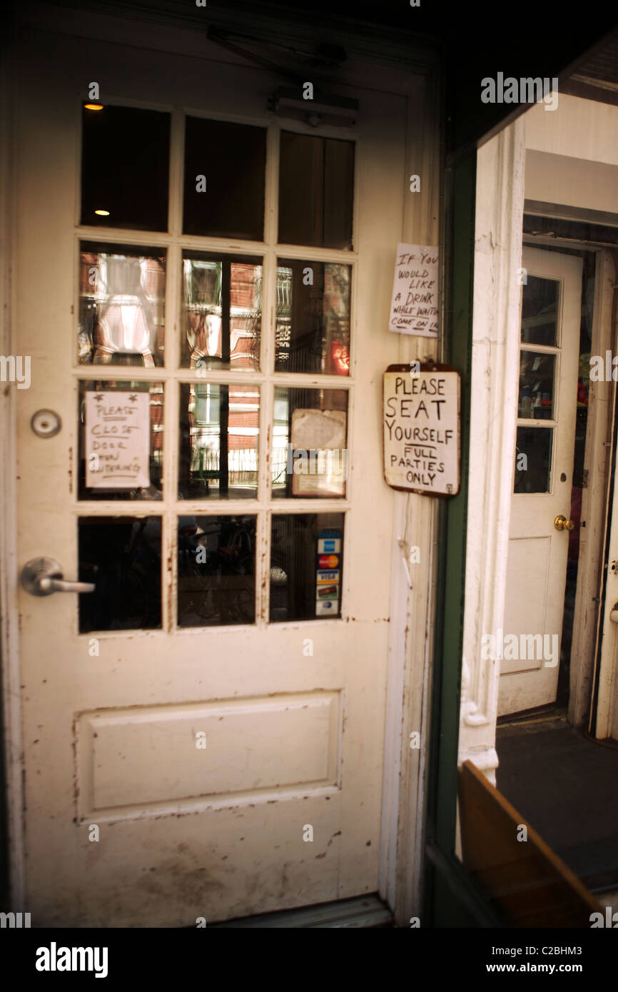 Ingresso di un ristorante nel West Village Manhattan New York con vari segni stravagante bloccato al portello. Foto Stock